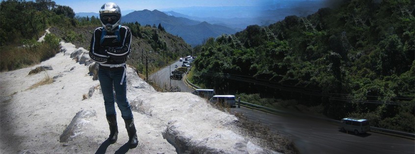 a lady with motorcycle gear and a view